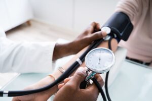 doctor checking blood pressure on complex hypertension patient